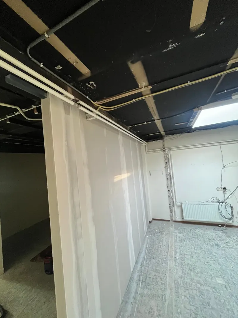 Leidingen boven de nieuwe wand, klaar om weg te werken
