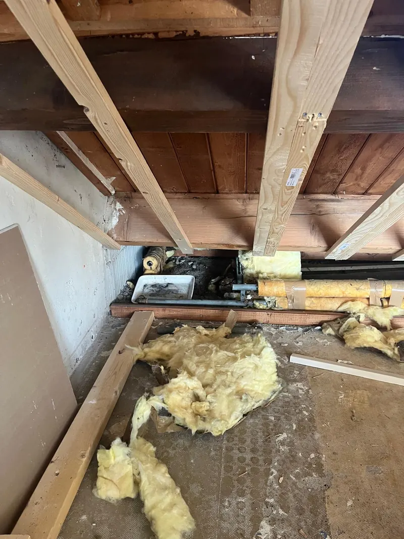 Open vloer met oude leidingen tijdens een renovatie